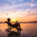 Mann sitzt im Liegestuhl am Strand